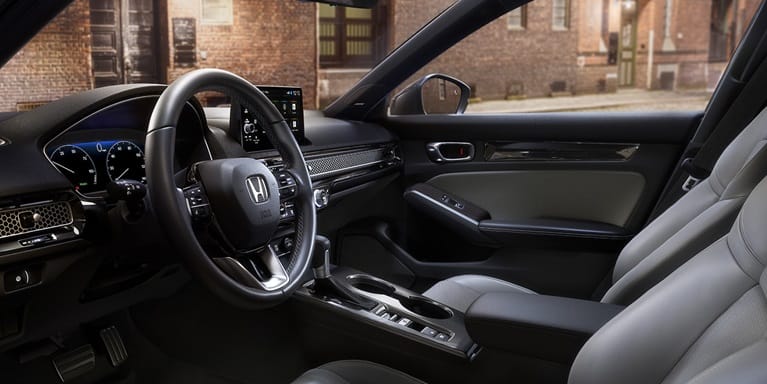 2027 Honda Civic Hatchback Touring Hybrid front cabin with leather-trimmed seats and dashboard (Compact Hatchback).